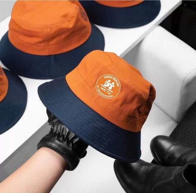 May nón đồng phục Dĩ An